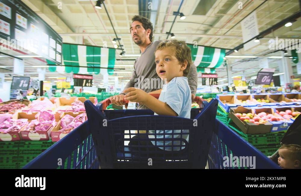 A father shopping with his son inside the sopping cart Stock Video ...