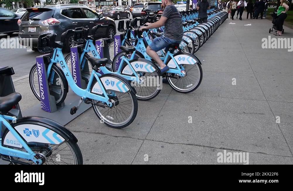 People returning bicycles to a Divvy bikes docking station Chicago city