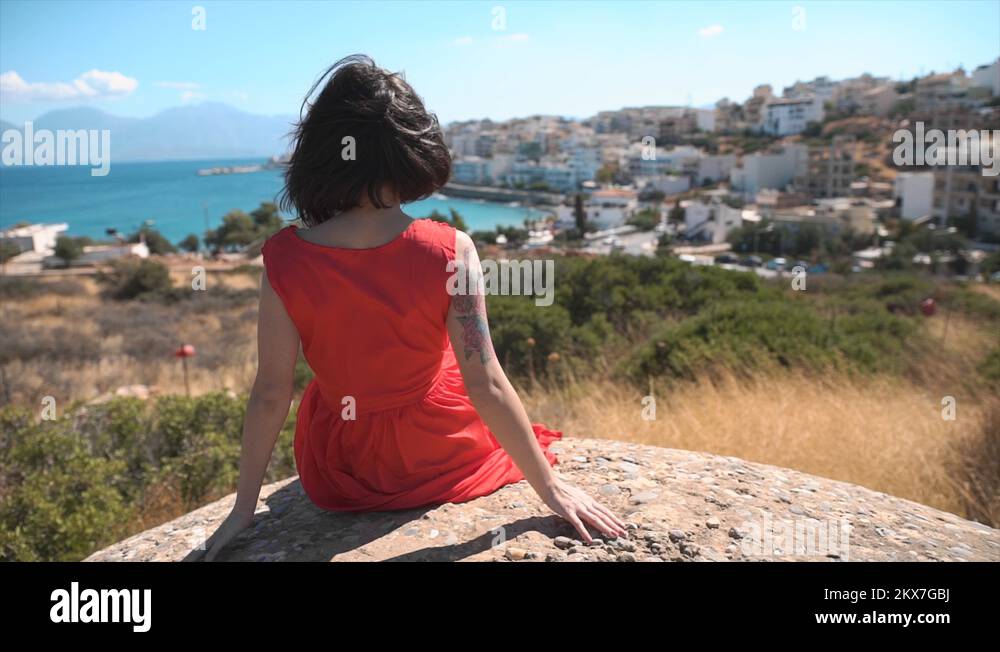 Girl in red dress is looking over a Greek town Stock Video Footage - Alamy