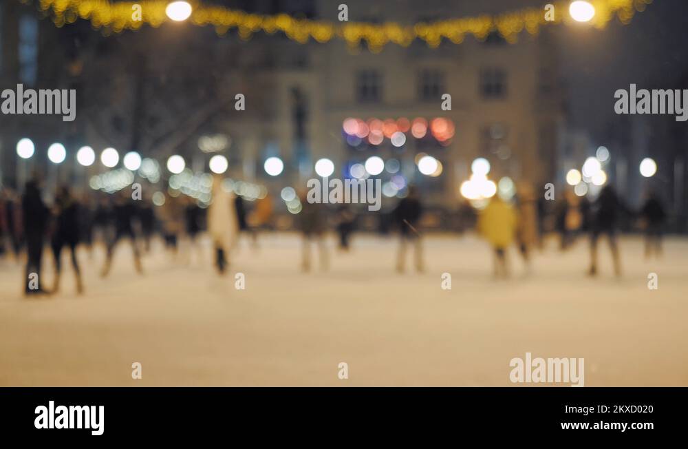 The open Ice Skating Rink at Night with crowd of young people. Long