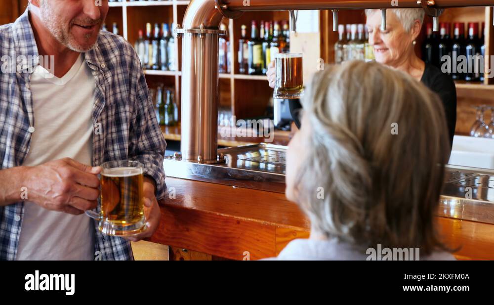 Friends interacting while having beer at counter in bar 4k Stock Video ...