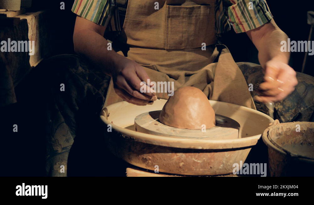 A potter wets a large lump of clay on a wheel Stock Video Footage - Alamy