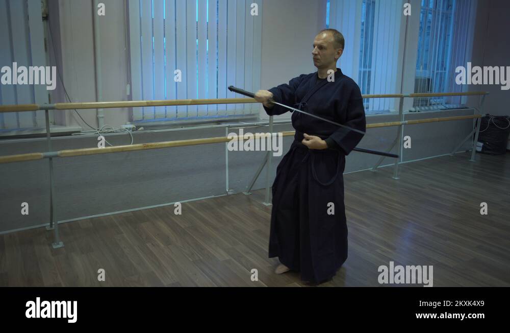 Master Kendoka Makes Kata Trains with Katana Sword in the Sports Hall
