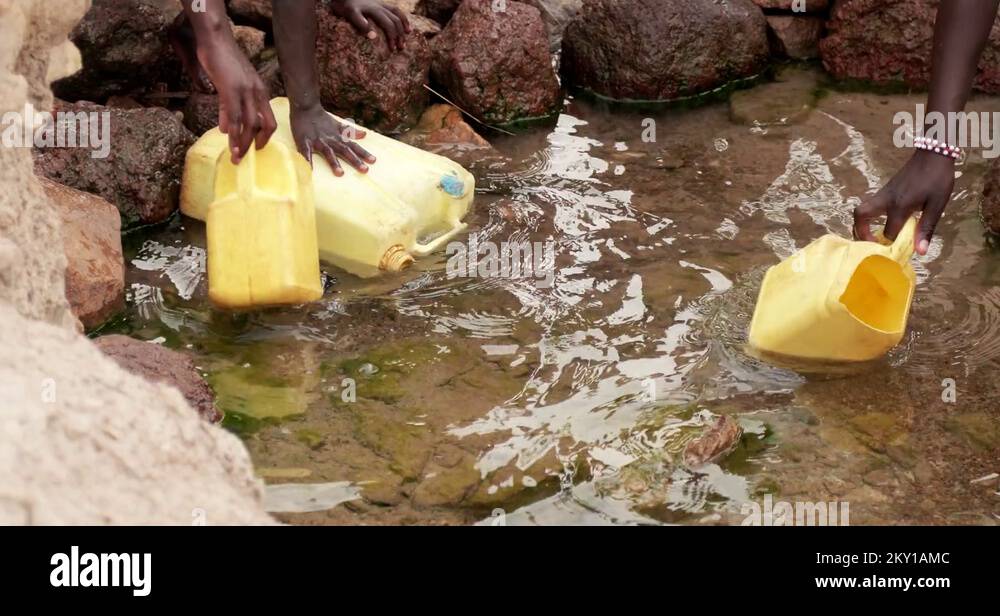African Children fetching dirty drinking water using bottles to fill sour water Stock Video