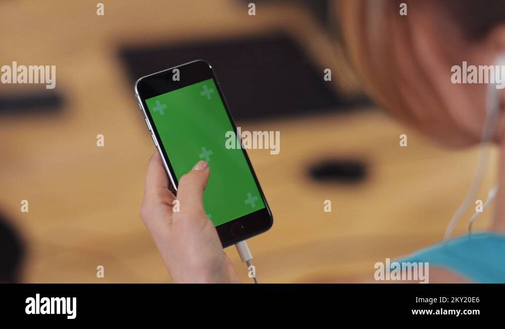 Close up hand woman use phone with vertical green screen in sport club ...