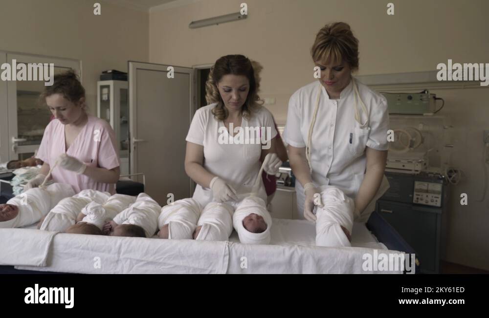 Nurses changing diapers a newborn babies at hospital maternity ward
