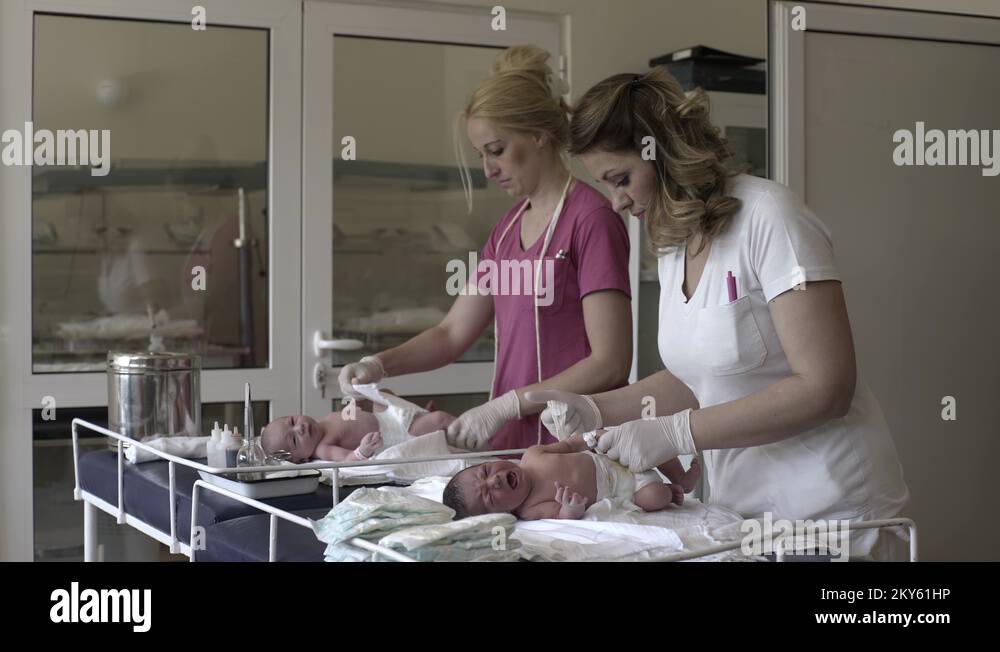 Nurses dressing diapers the newborn babies at hospital maternity ward