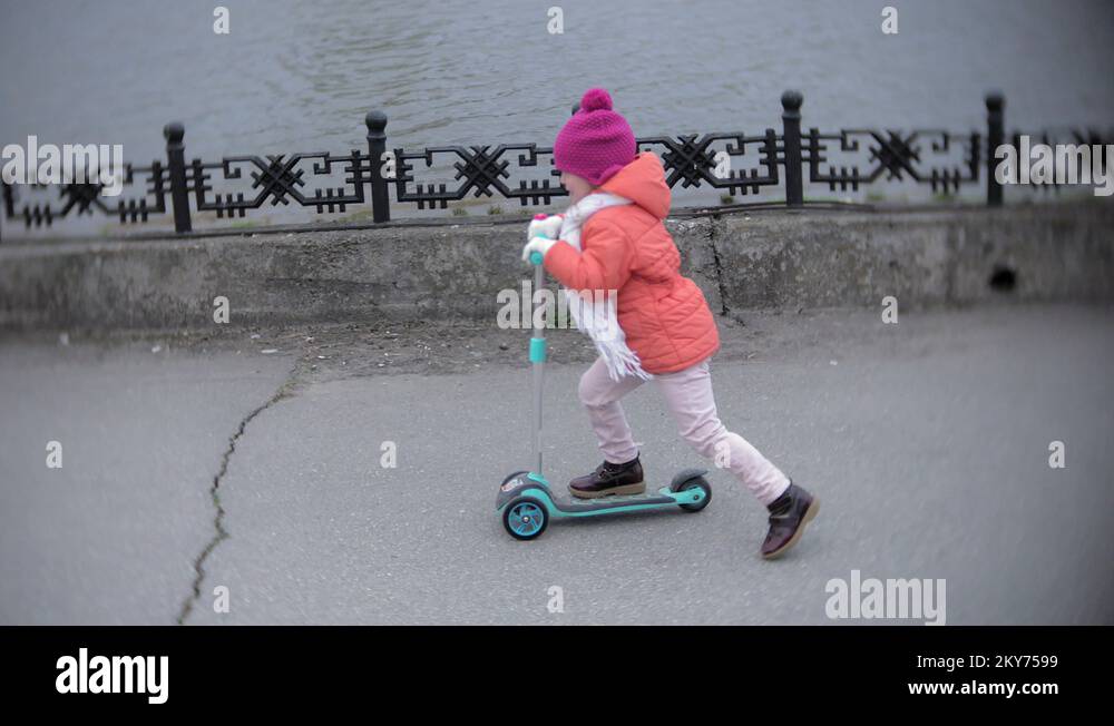 little girl in helmet riding a kick scooter Stock Video Footage Alamy