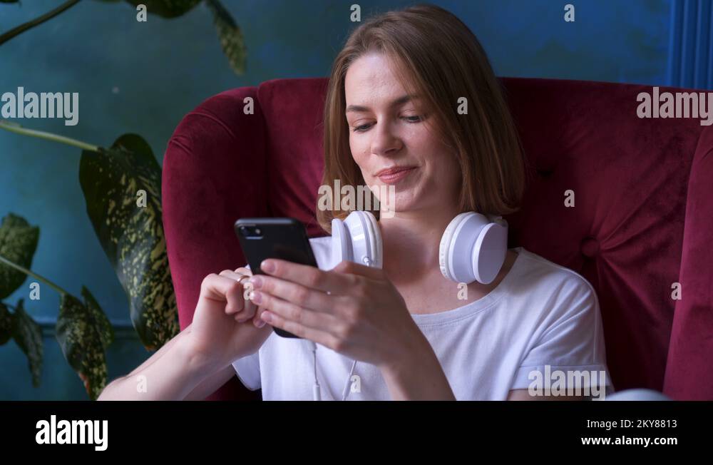 Girl putting on headphones and starting listen to music Stock Video