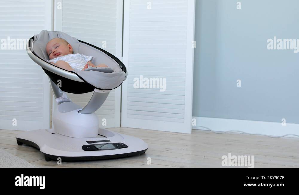 Sweet newborn baby girl sleeping in a bouncer chair in a white room Stock Video Footage Alamy