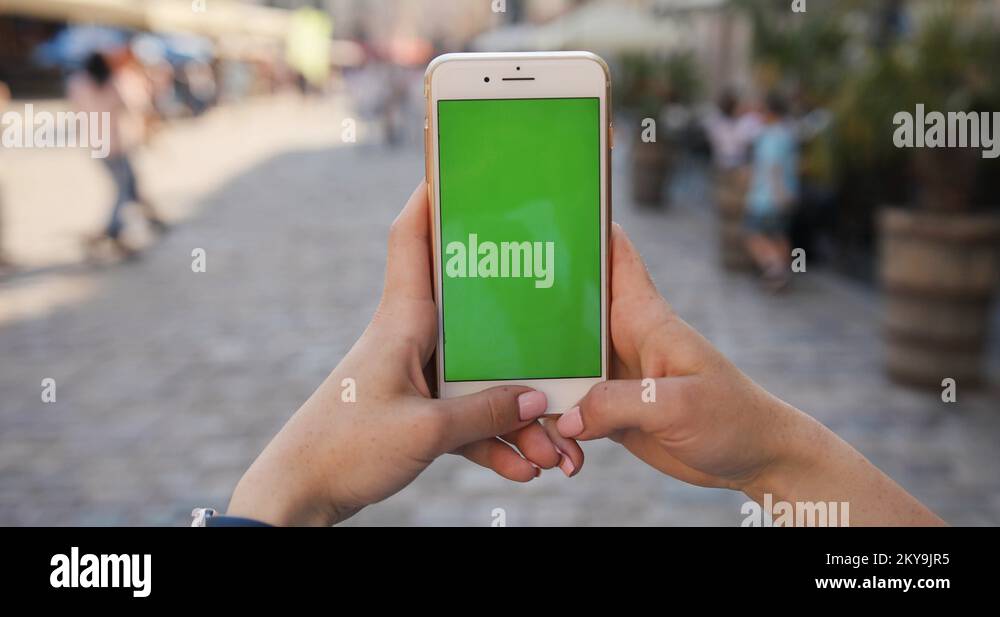 woman hand holding mobile smart phone with vertical green screen ...