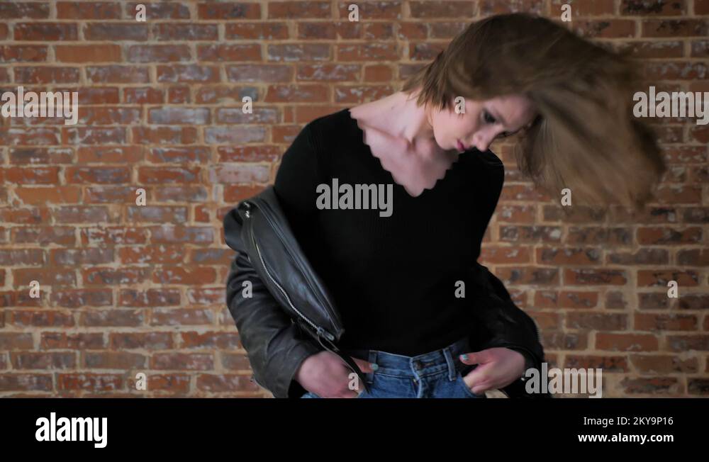 Young sexy girl with smoky eyes is dancing, shaking head, rock music