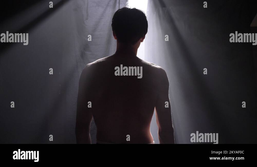 Boxer standing and waiting in dark room with smoke and going to fight