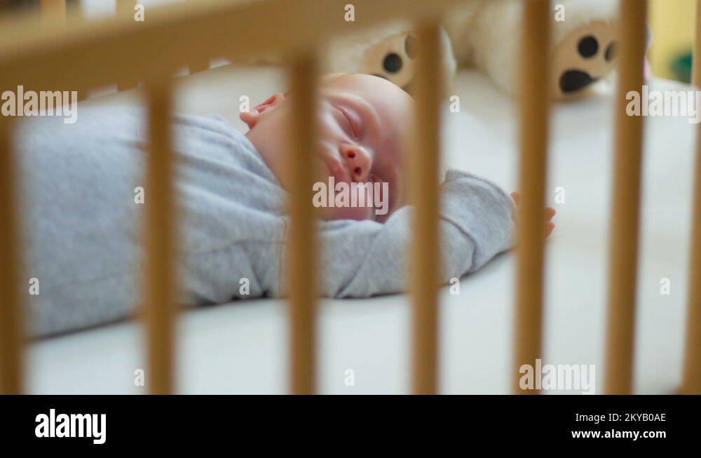 Mother cover her baby with a blanket in a white bed, warm concept and