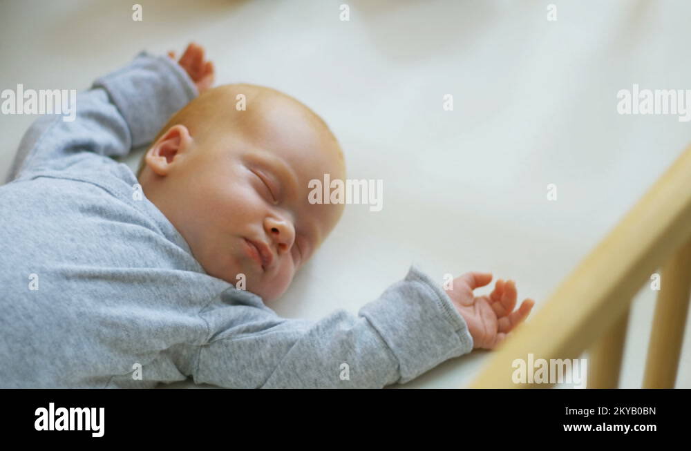 Mother cover her baby with a blanket in a white bed, warm concept and