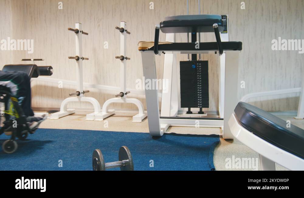 Disabled man sitting in the wheelchair, doing exercise and takes a dumbbell Stock Video Footage