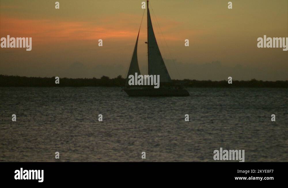 Fractional Rig Sloop sailing boat sailing right to left with sunset
