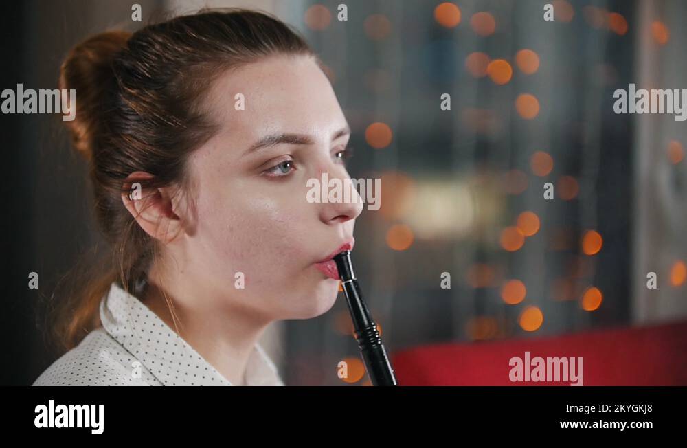 Pretty girl in a bar smoking a hookah. Blowing circles out of smoke