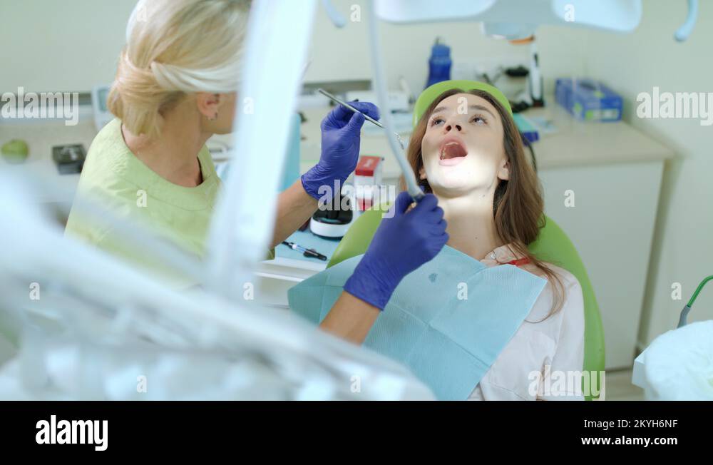 Dentist drilling tooth of woman. Doctor working with patient in dental