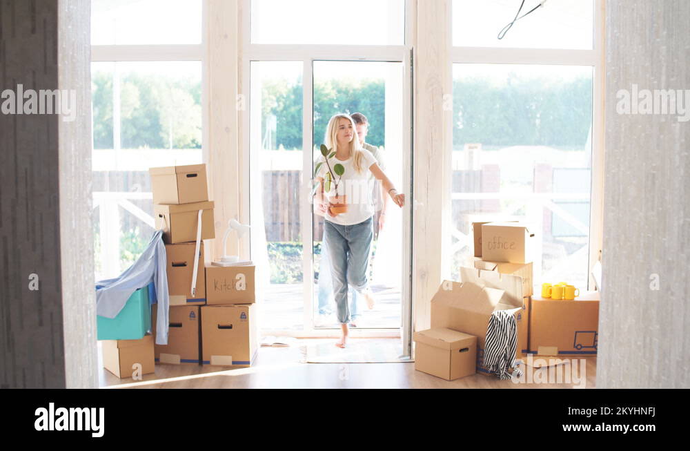 Happy Couple Carrying Cardboard Boxes Into New Home On Moving Day Stock ...