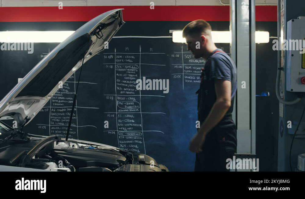 Repair man opening hood and checking engine in car service. Auto repair
