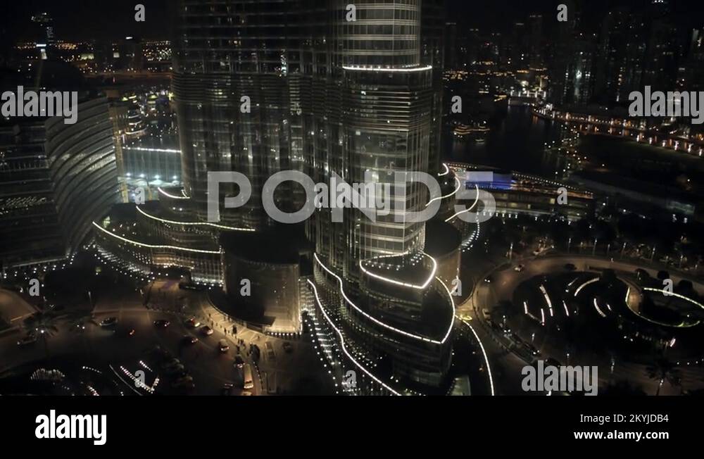 Track left at 100m and lift up at base of Burj Khalifa, night Stock