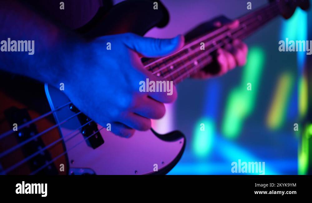 Closeup of bass player hands playing music with bass guitar with