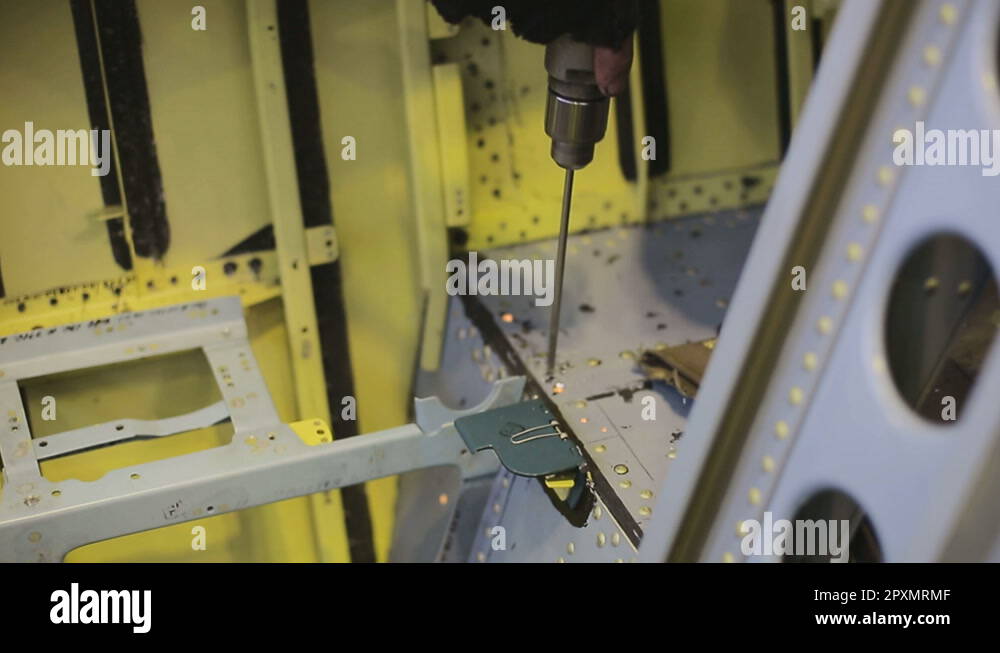Drilling holes in body of plane between baffles with a drill bit Stock