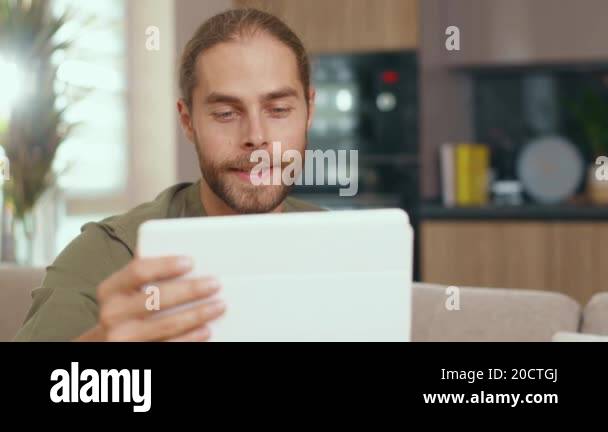 Handsome nice caucasian man using tablet computer tapping on screen ...