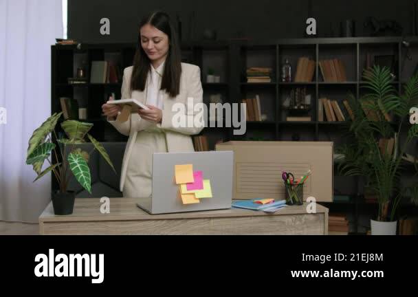 Young entrepreneur packing her personal belongings in a box from her ...