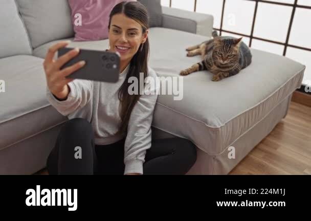 Young woman taking a selfie while sitting on the floor in her cozy ...