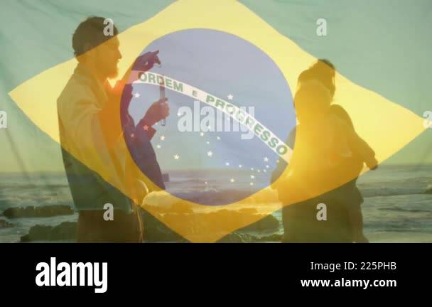 Animation of flag of brazil over caucasian parents with baby at beach ...