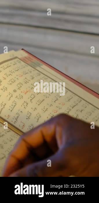 African Man hand reading quran, the teenager is rummaging through the ...