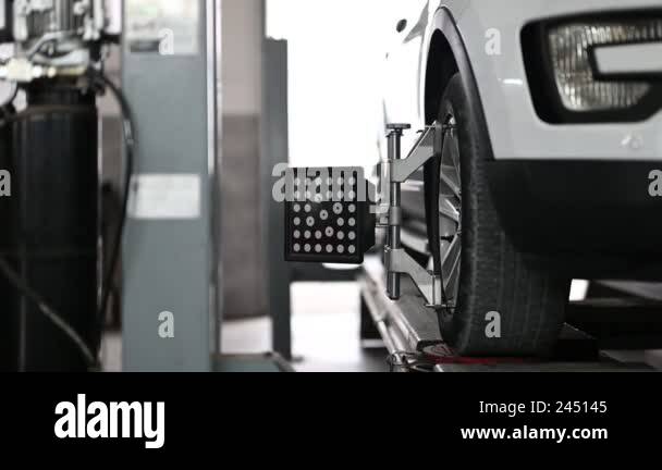 Close-up shot of car wheel alignment process in a modern service ...