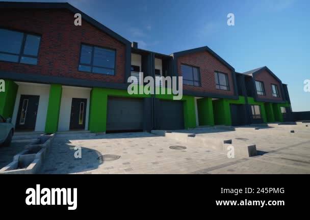 View of Modern townhouses featuring a sleek design with brick and green accents ...