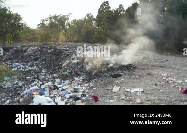 Garbage, fire burning and smoke in landfill. Also called trash, waste ...