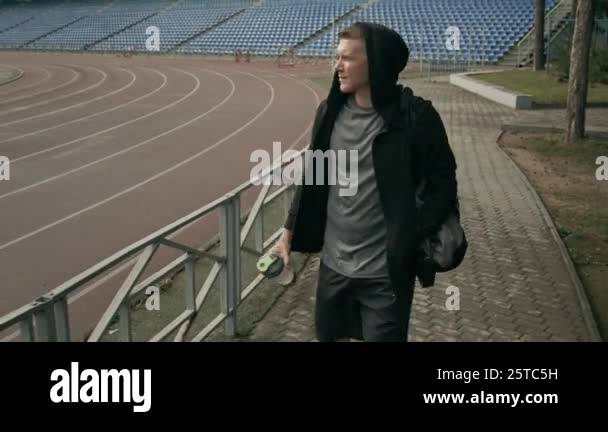 Medium tracking shot of cheerful young Caucasian male athlete in black ...