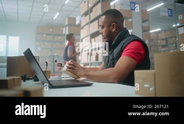 Portrait of African American post office employee scanning parcel with ...