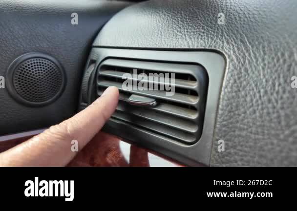 Gently adjusting the airflow from a car air vent by using just a finger ...