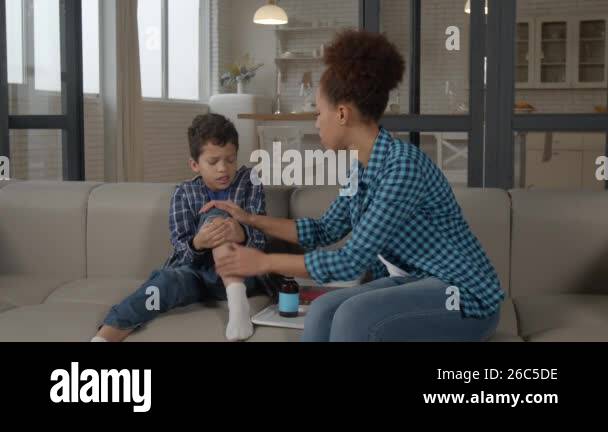 Caring African American mother with antiseptic and wet wipe providing ...