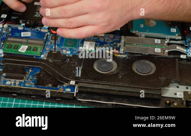 Picture of Unrecognizable man repairing laptop motherboard with screwdriver. Male ...