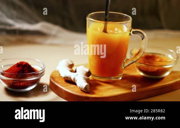 Immunity drink with turmeric powder in transparent glass. Homemade ...