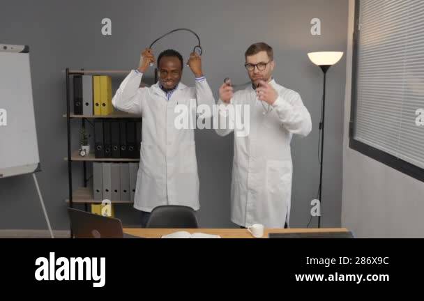 Two men in white lab coats standing together near desk Stock Video ...