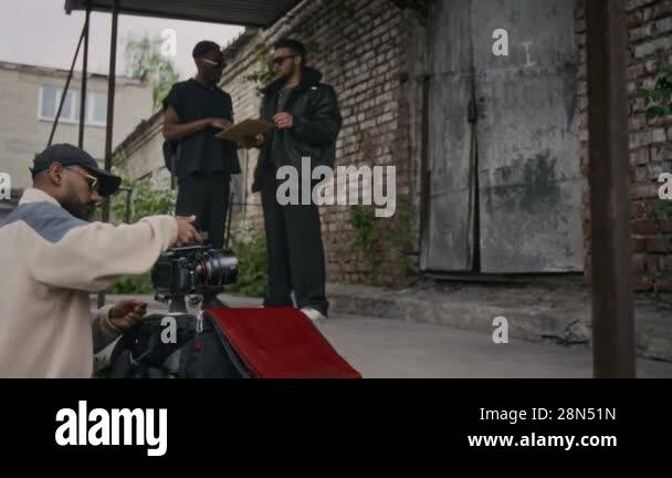 Side full shot music artists preparing for recording clip outside of ...