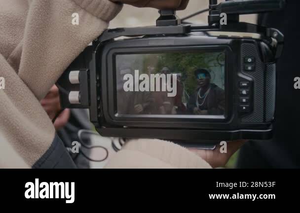 Close-up shot of hands of anonymous videographer holding camera playing ...