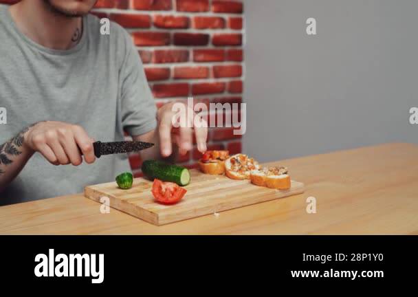 Home cooking daily routine. Man preparing lunch. Man sitting at table ...