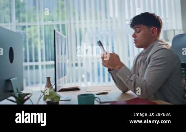 Two professionals using smartphones talking at modern office desk ...