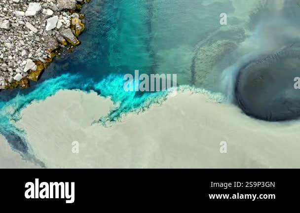 Two rivers meet without mixing in Iceland, clear water and muddy water ...