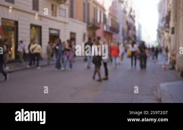 People walking along a vibrant street in rome with blurred architecture ...