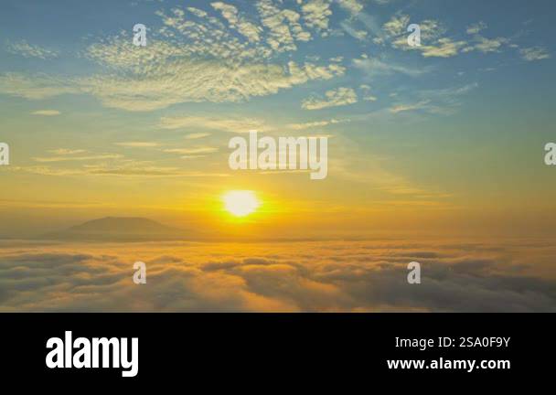 A serene view of the early morning sun rising above a vast sea of ...